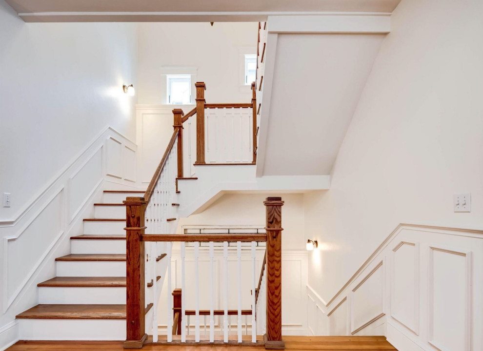 This is an example of a mid-sized wood u-shaped staircase in Denver with wood risers, wood railing and decorative wall panelling.