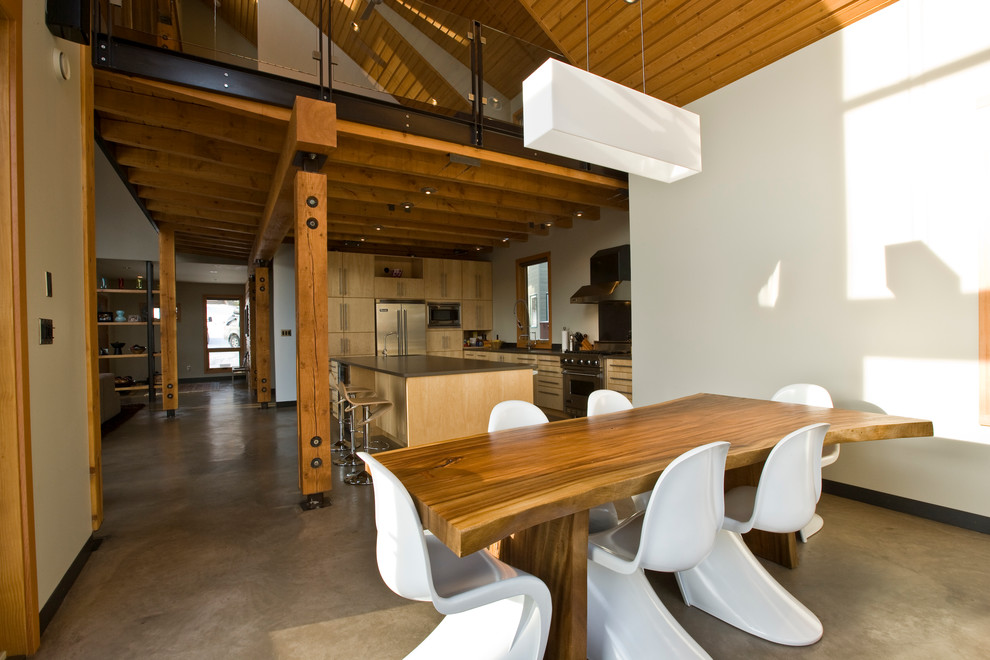 Inspiration for a modern kitchen/dining combo in Calgary with white walls and concrete floors.