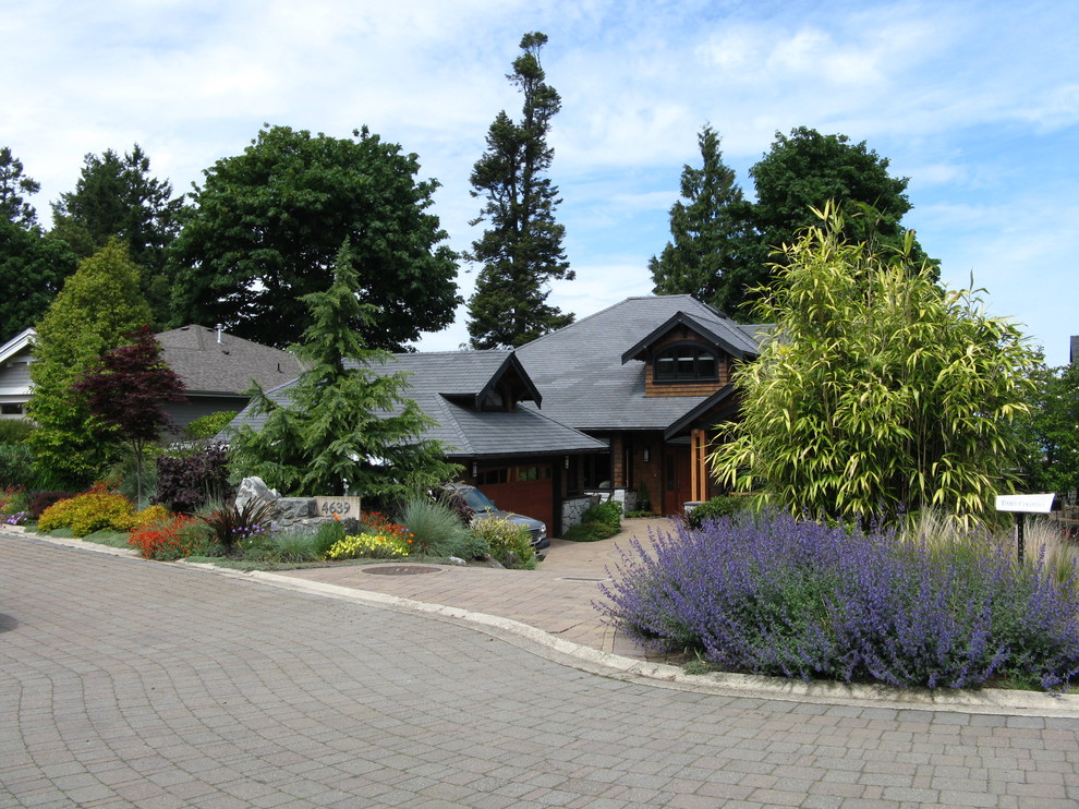 Design ideas for a large traditional front yard full sun driveway in Vancouver with brick pavers.