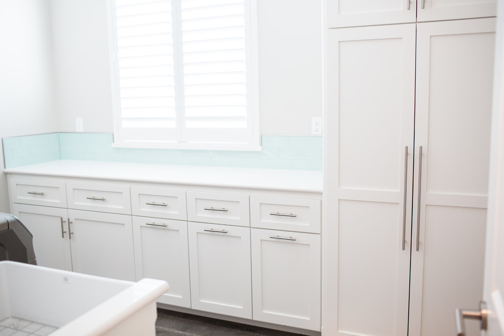 Design ideas for a modern galley dedicated laundry room in Other with a farmhouse sink, shaker cabinets, white cabinets, grey walls, vinyl floors and a side-by-side washer and dryer.