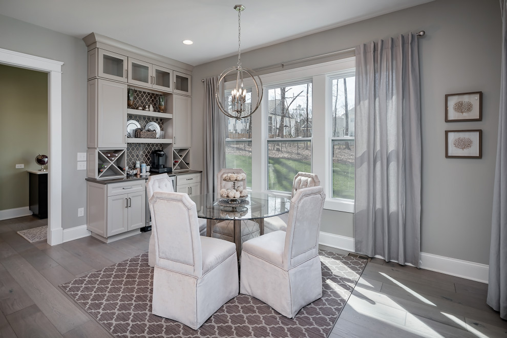 Photo of a mid-sized dining room in Charlotte with grey walls and light hardwood floors.