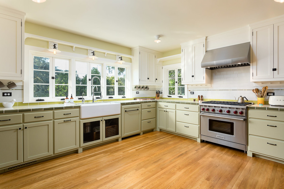 Design ideas for a traditional u-shaped separate kitchen in Los Angeles with a farmhouse sink, shaker cabinets, green cabinets, tile benchtops, multi-coloured splashback, subway tile splashback, stainless steel appliances and medium hardwood floors.