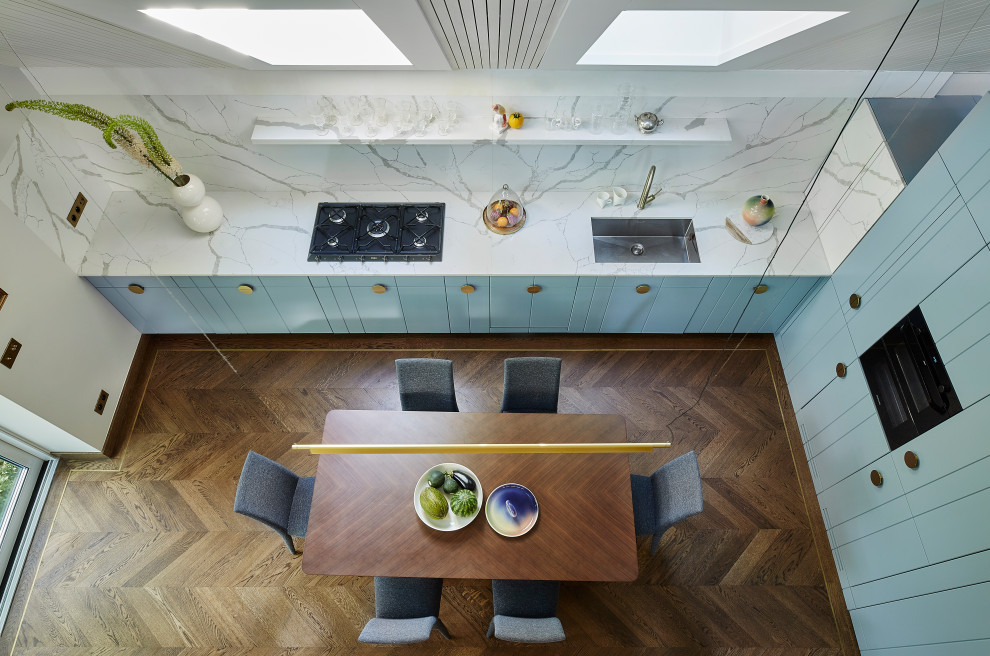 Eat-in kitchen - mid-sized contemporary l-shaped medium tone wood floor and vaulted ceiling eat-in kitchen idea in London with an undermount sink, flat-panel cabinets, turquoise cabinets, solid surface countertops, red backsplash, black appliances, no island and white countertops