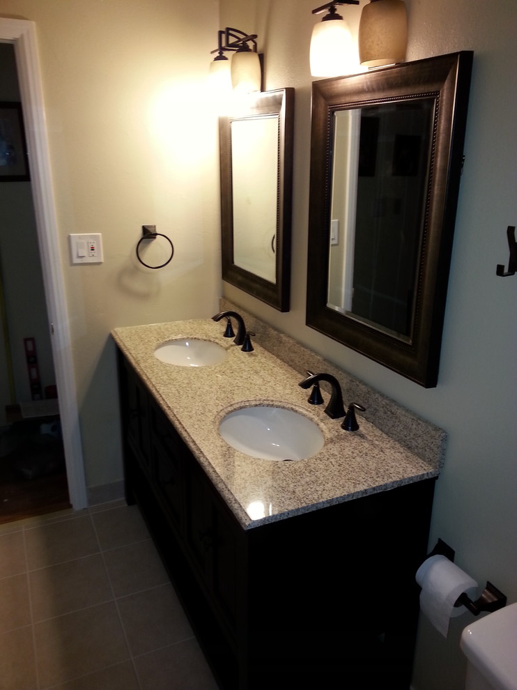 Alcove bathtub - mid-sized transitional 3/4 porcelain tile and beige floor alcove bathtub idea with furniture-like cabinets, dark wood cabinets, a two-piece toilet, beige walls, an undermount sink, solid surface countertops and multicolored countertops