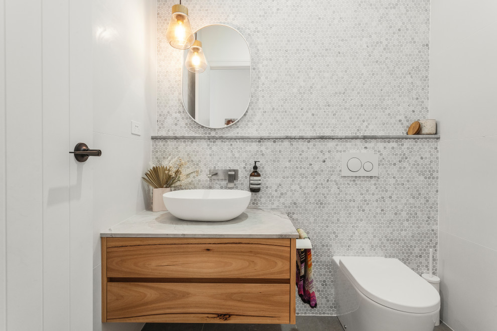 Idées déco pour un WC et toilettes contemporain de taille moyenne avec du carrelage en marbre, un plan de toilette en marbre et meuble-lavabo suspendu.
