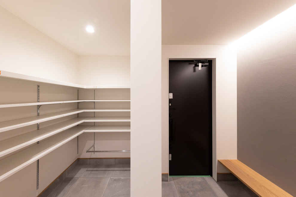 Inspiration pour une entrée minimaliste avec un couloir, un mur gris, un sol en carrelage de porcelaine, une porte simple, une porte noire, un sol gris, un plafond en papier peint et du lambris de bois.