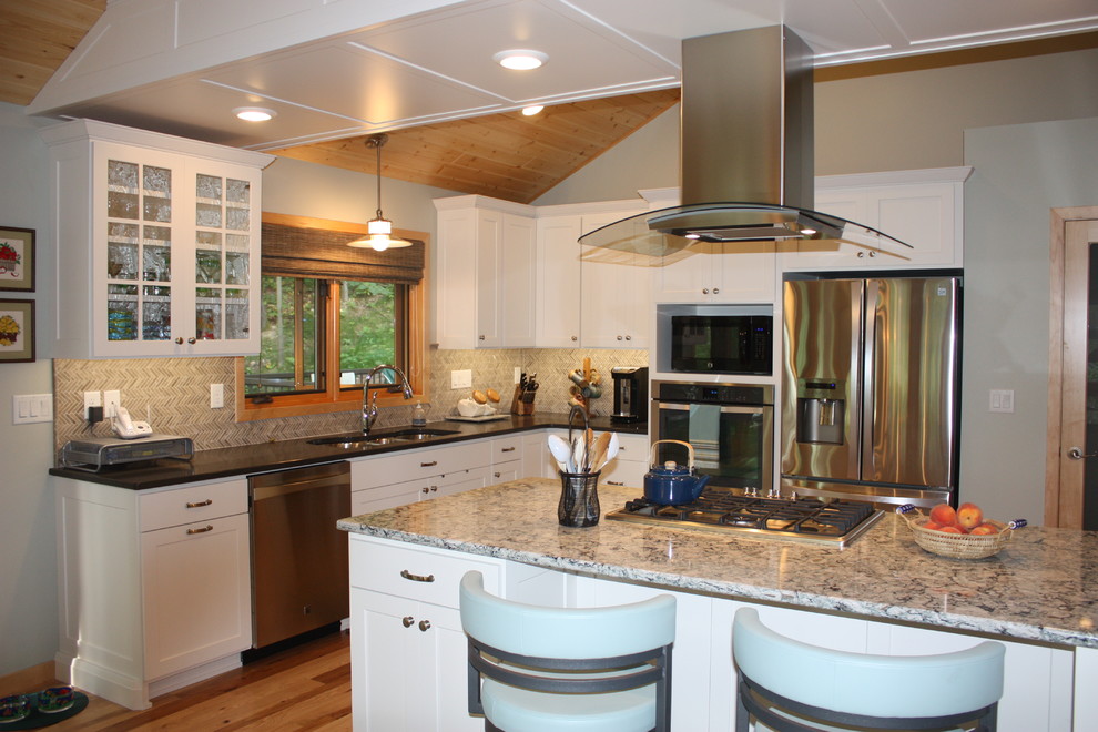 Inspiration for a large transitional l-shaped medium tone wood floor open concept kitchen remodel with a triple-bowl sink, recessed-panel cabinets, white cabinets, solid surface countertops, multicolored backsplash, mosaic tile backsplash, stainless steel appliances and an island