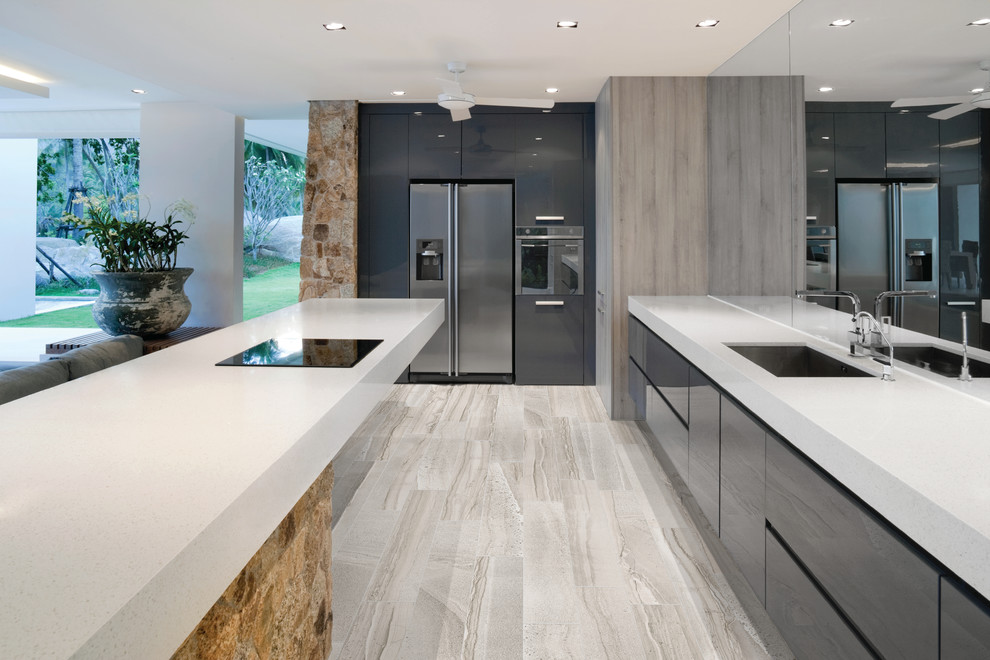 Design ideas for a large modern single-wall eat-in kitchen in Philadelphia with an undermount sink, flat-panel cabinets, black cabinets, soapstone benchtops, stainless steel appliances, laminate floors and with island.