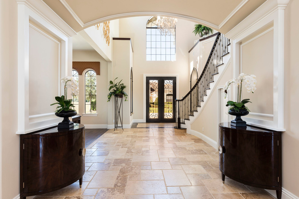 Large traditional foyer in Orlando with beige walls, a double front door, a dark wood front door, beige floor and limestone floors.