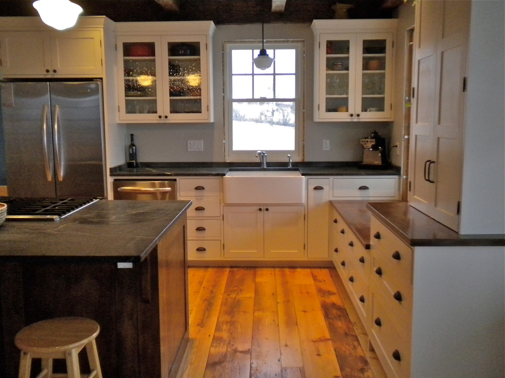 Inspiration for a mid-sized country l-shaped eat-in kitchen in Other with a farmhouse sink, shaker cabinets, white cabinets, soapstone benchtops, stainless steel appliances, medium hardwood floors and with island.