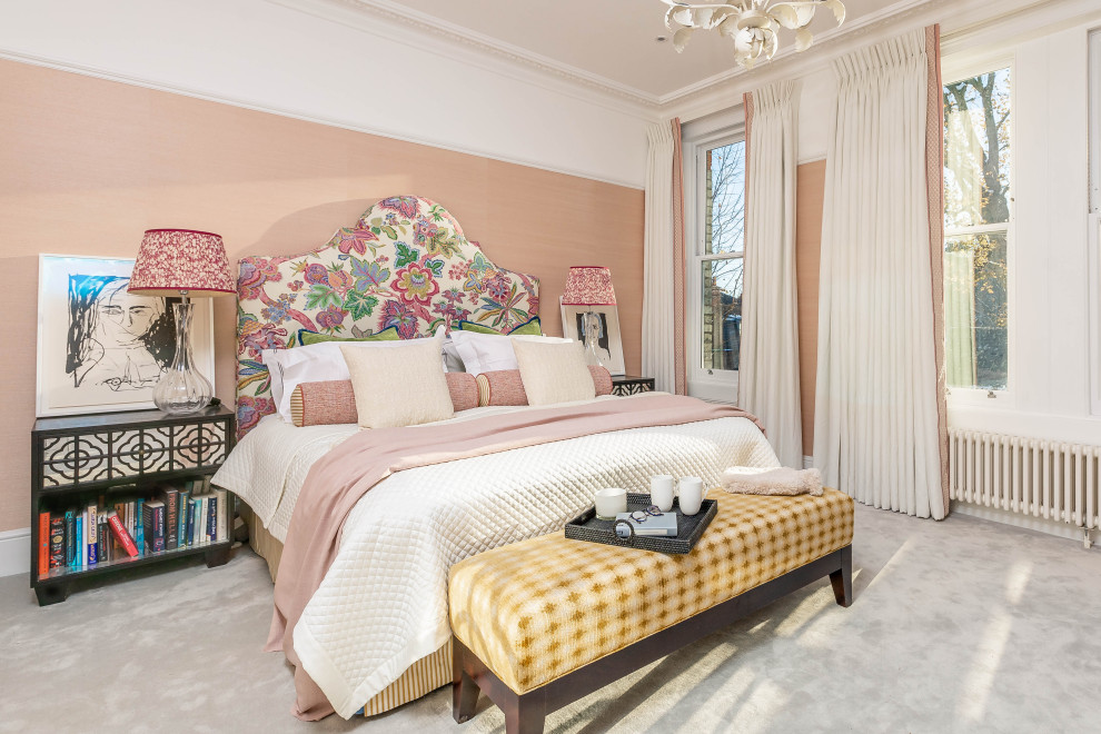 Photo of a large eclectic master bedroom in London with pink walls, carpet, grey floor and wallpaper.