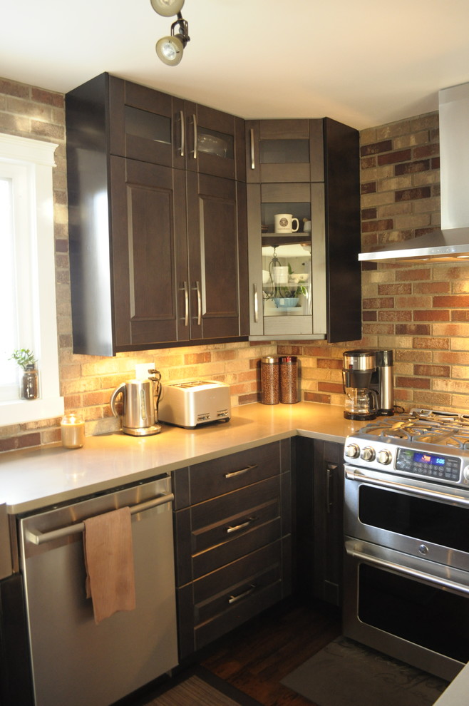 Mountain style eat-in kitchen photo in Calgary with a farmhouse sink, shaker cabinets, dark wood cabinets, quartz countertops, brown backsplash, stone tile backsplash, stainless steel appliances, an island and gray countertops