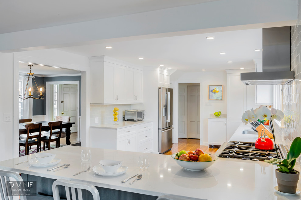 Inspiration for a mid-sized transitional l-shaped eat-in kitchen in Boston with an undermount sink, white cabinets, quartz benchtops, grey splashback, ceramic splashback, stainless steel appliances, a peninsula, brown floor, shaker cabinets and medium hardwood floors.