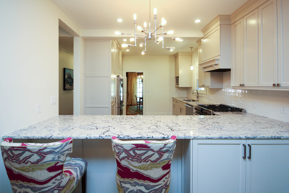 Example of a transitional l-shaped porcelain tile open concept kitchen design in Raleigh with an undermount sink, shaker cabinets, gray cabinets, granite countertops, white backsplash, subway tile backsplash and stainless steel appliances