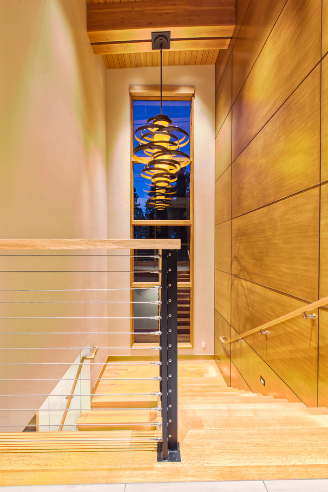 Foto de escalera suspendida moderna pequeña con escalones de madera, contrahuellas de madera, barandilla de cable y madera