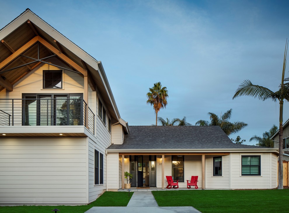 This is an example of a contemporary two-storey white house exterior in San Diego with a gable roof and a shingle roof.