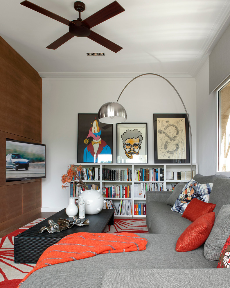 Photo of a mid-sized contemporary open concept living room in Barcelona with a library, white walls and a wall-mounted tv.