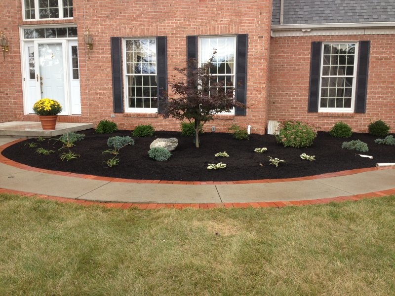 This is an example of a mid-sized transitional full sun front yard brick driveway for summer.