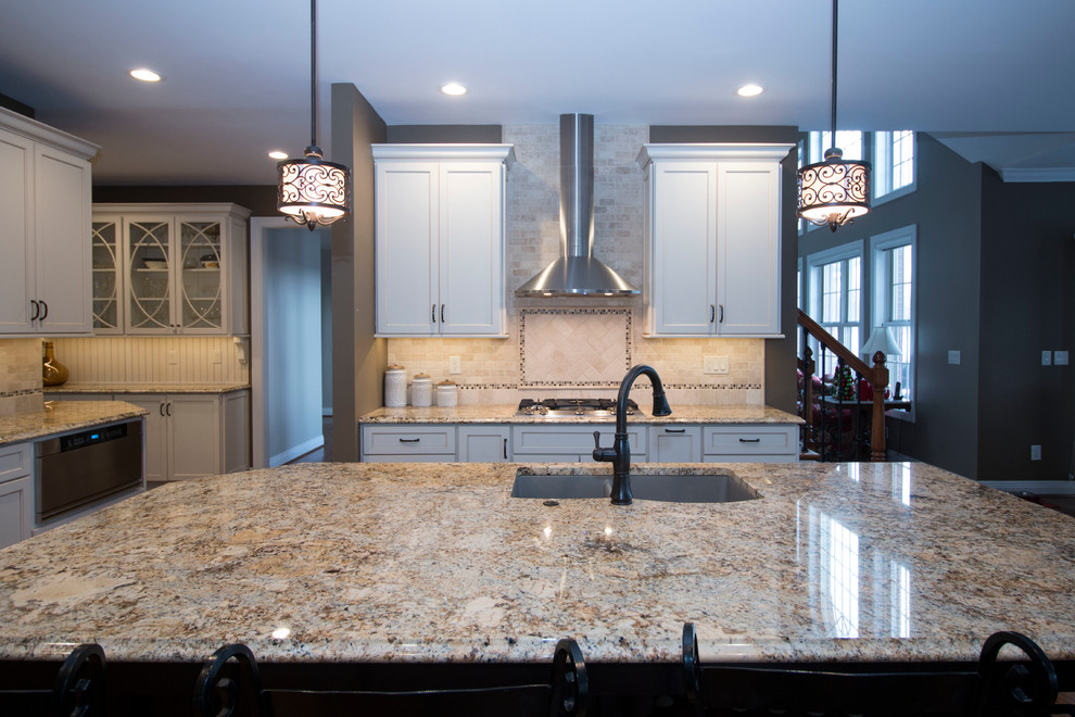Inspiration for a large traditional l-shaped eat-in kitchen in Cincinnati with an undermount sink, shaker cabinets, white cabinets, granite benchtops, beige splashback, stone tile splashback, stainless steel appliances, medium hardwood floors and with island.