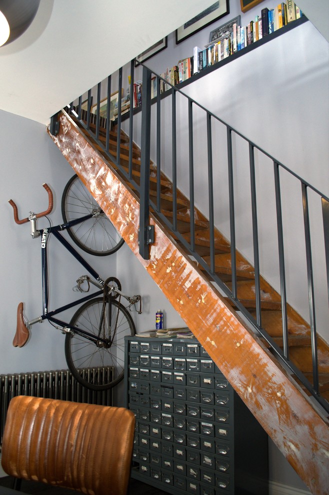 Inspiration for a small industrial wood straight staircase in Other with open risers and metal railing.