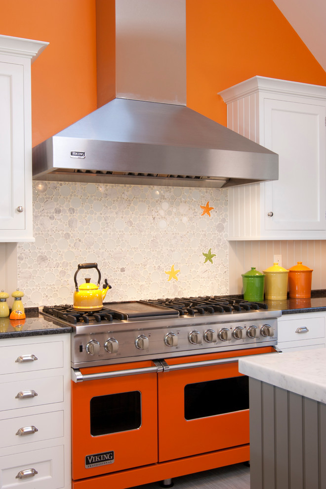 Eat-in kitchen - transitional u-shaped eat-in kitchen idea with white cabinets, marble countertops, white backsplash, glass tile backsplash, colored appliances and a peninsula