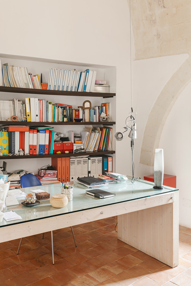 Photo of a mediterranean home studio in Other with terra-cotta floors.