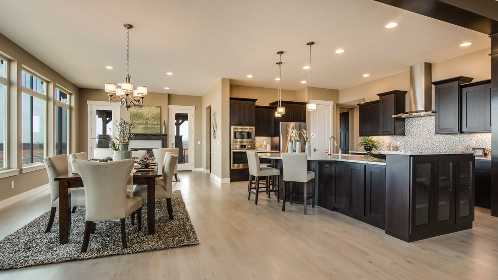 Eat-in kitchen - large transitional l-shaped light wood floor eat-in kitchen idea in Denver with granite countertops, gray backsplash, stainless steel appliances, an island, shaker cabinets, dark wood cabinets and mosaic tile backsplash