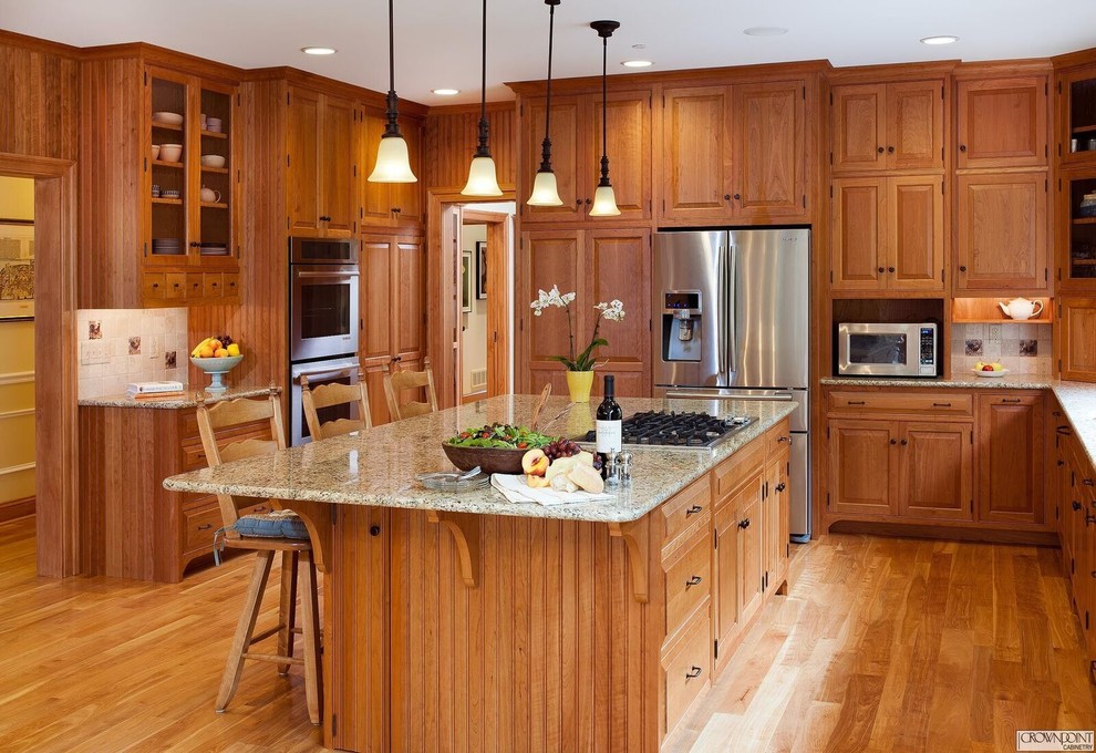 Example of a transitional u-shaped eat-in kitchen design in DC Metro with raised-panel cabinets, medium tone wood cabinets and an island