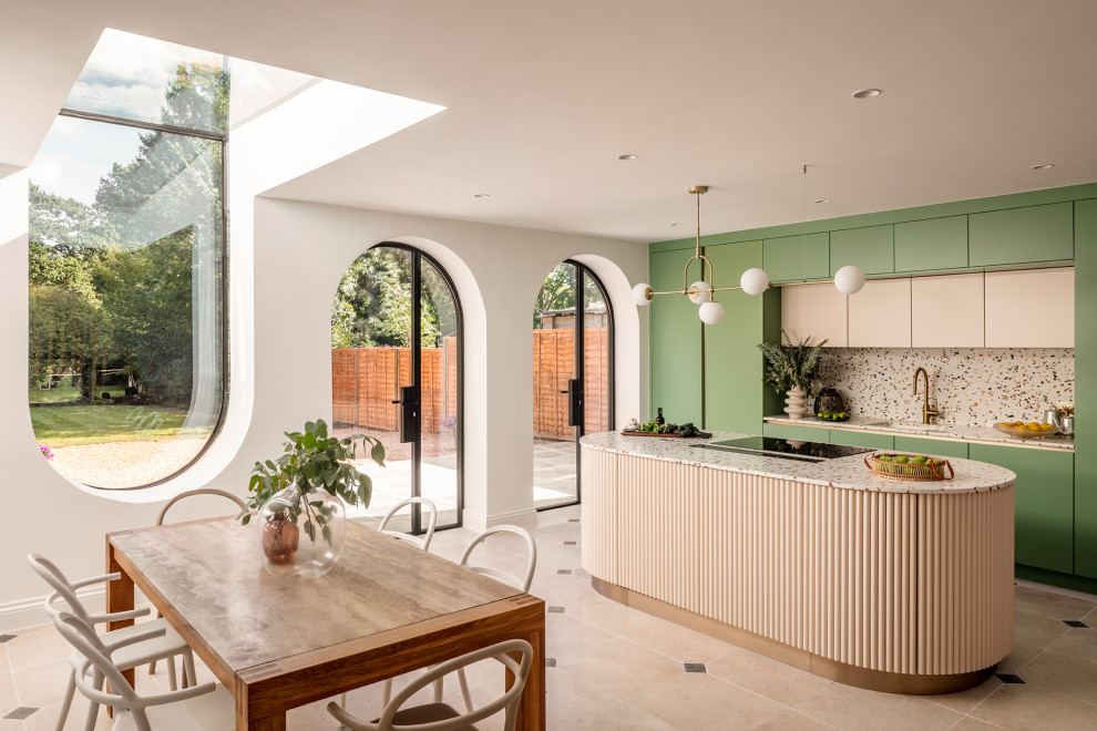 This is an example of a mid-sized contemporary single-wall open plan kitchen in Essex with an undermount sink, flat-panel cabinets, green cabinets, terrazzo benchtops, multi-coloured splashback, stainless steel appliances, limestone floors, with island and multi-coloured benchtop.