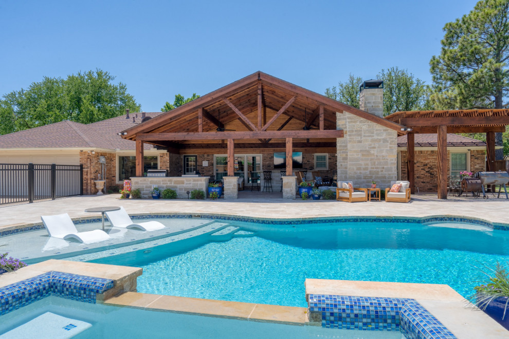 Design ideas for a large traditional backyard kidney-shaped natural pool in Austin with a hot tub and natural stone pavers.