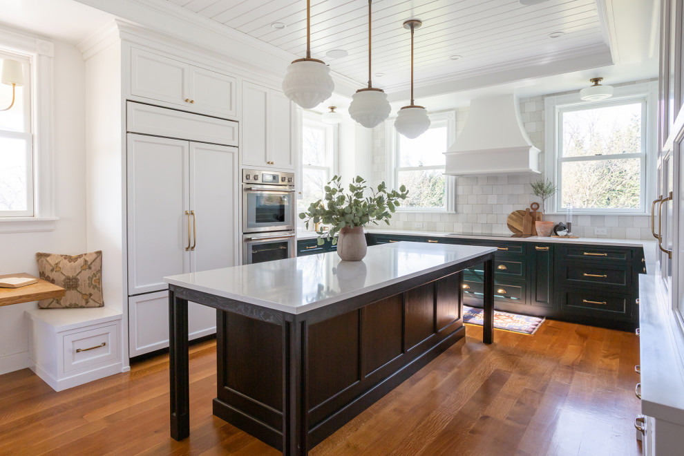 Exempel på ett avskilt, stort klassiskt vit vitt u-kök, med en undermonterad diskho, skåp i shakerstil, vita skåp, bänkskiva i kvarts, vitt stänkskydd, stänkskydd i keramik, integrerade vitvaror, mellanmörkt trägolv, en köksö och brunt golv