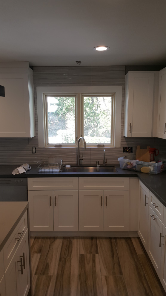 Idéer för att renovera ett stort funkis grå grått u-kök, med en nedsänkt diskho, skåp i shakerstil, vita skåp, bänkskiva i koppar, grått stänkskydd, stänkskydd i keramik, rostfria vitvaror, ljust trägolv och brunt golv