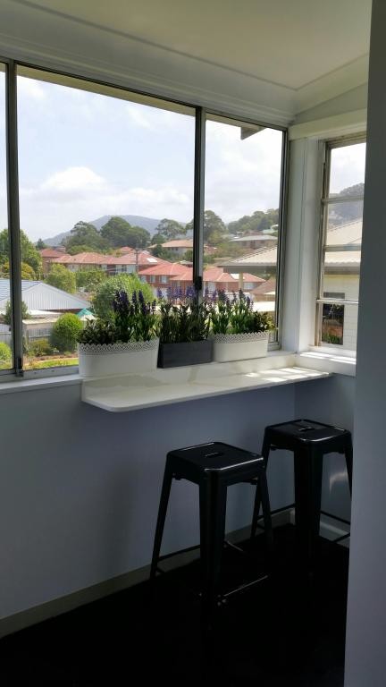 This is an example of a small sunroom in Wollongong with dark hardwood floors.