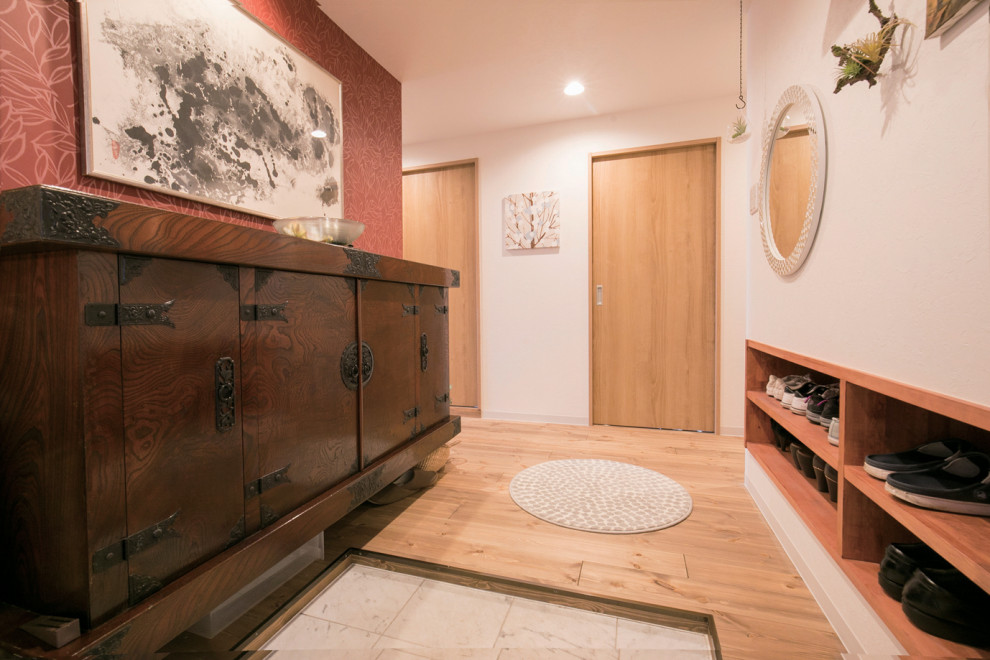 Inspiration for an asian entryway in Fukuoka with red walls, dark hardwood floors, a single front door, a metal front door, wallpaper and wallpaper.