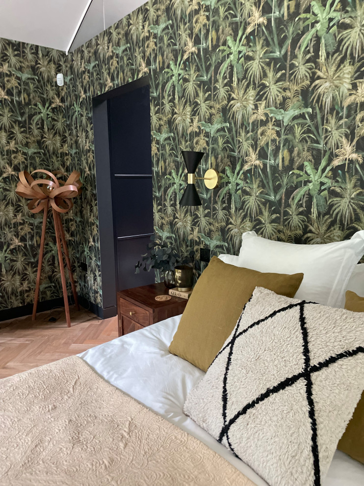 Großes Modernes Hauptschlafzimmer mit grüner Wandfarbe, braunem Holzboden, Kaminofen, Kaminumrandung aus Beton, braunem Boden, gewölbter Decke und Tapetenwänden in Hertfordshire