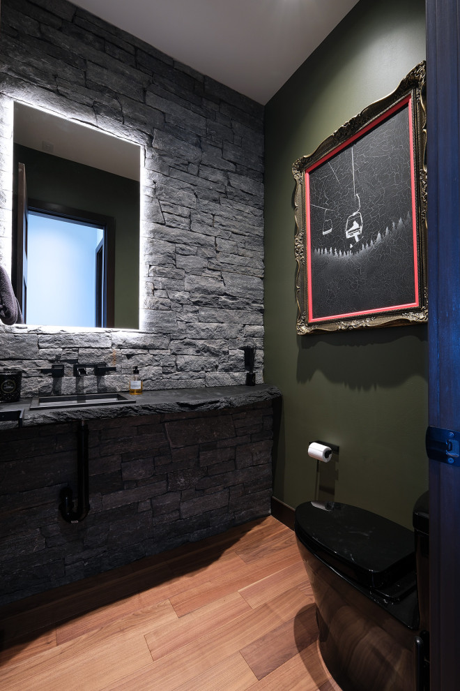 Exemple d'un WC et toilettes montagne avec un carrelage gris, un carrelage de pierre, un mur vert, un sol en bois brun, un plan de toilette en bois, un sol marron et un plan de toilette noir.