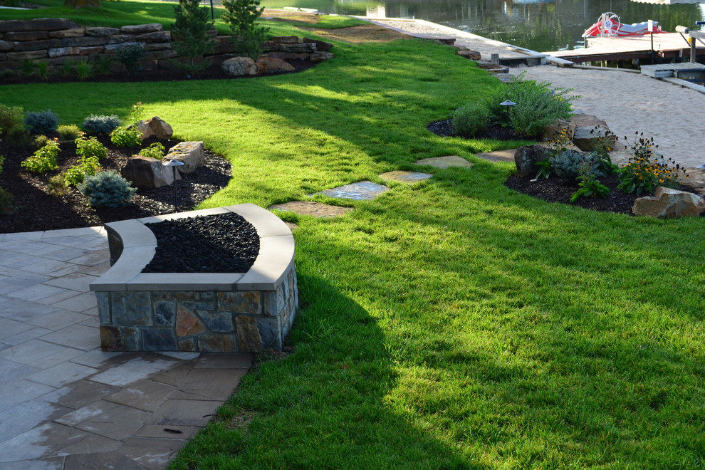 Inspiration for a rustic front yard stone landscaping in Omaha with a fire pit.