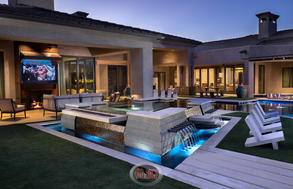 Example of a huge mountain style backyard stone and custom-shaped infinity pool fountain design in Phoenix