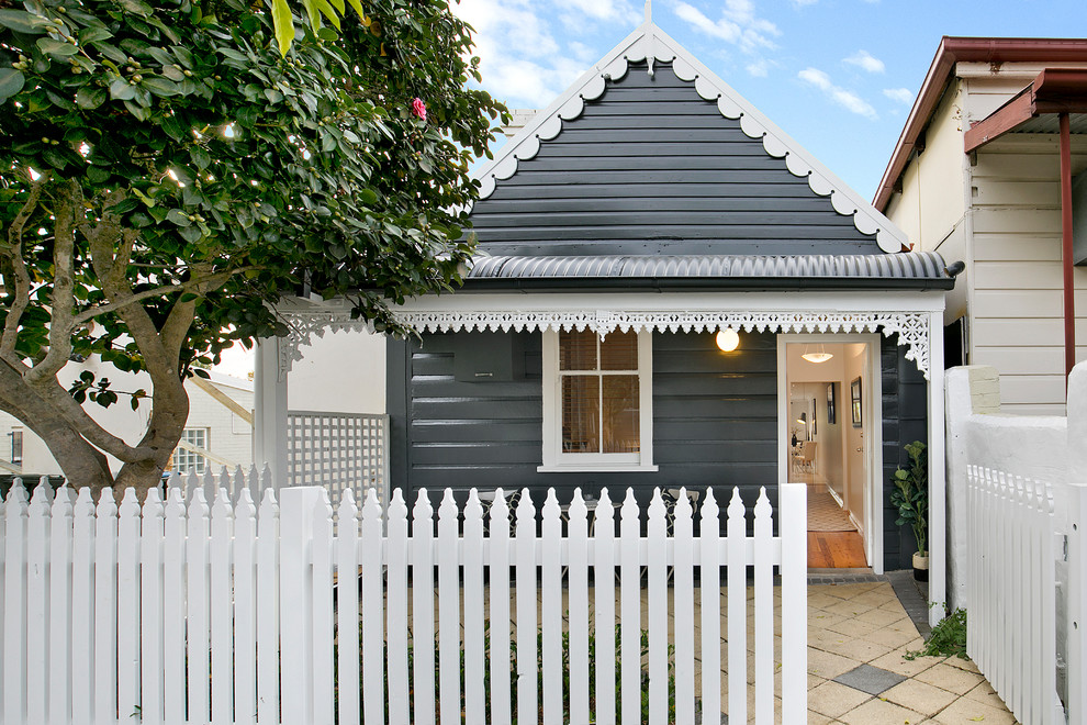 Inspiration for a beach style one-storey black house exterior in Sydney with a gable roof.
