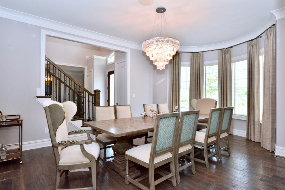 Photo of a mid-sized transitional dining room in New York with grey walls, dark hardwood floors and brown floor.