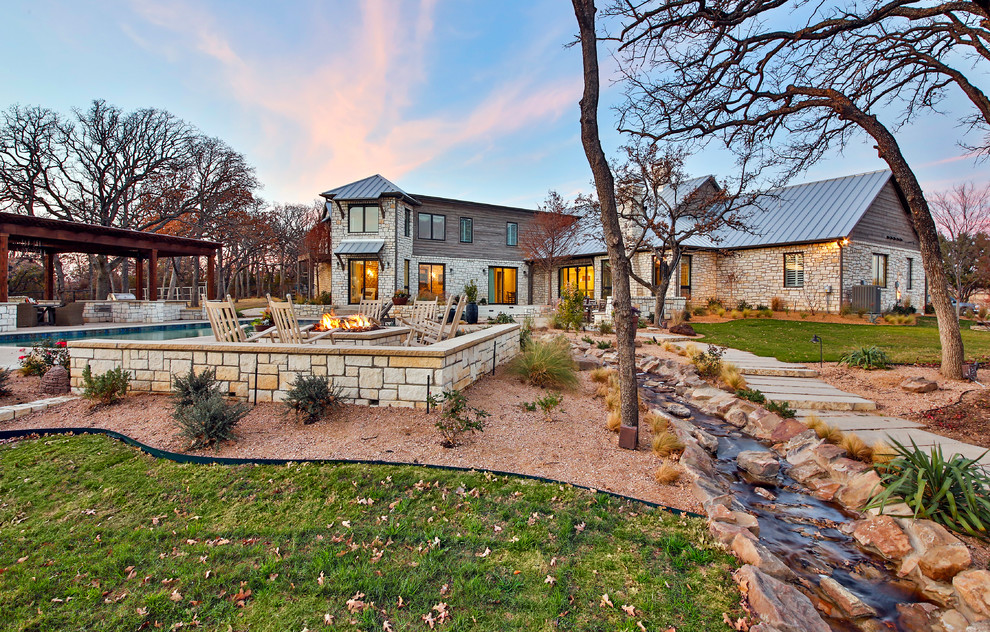Expansive contemporary backyard full sun garden in Dallas with a water feature and natural stone pavers for spring.