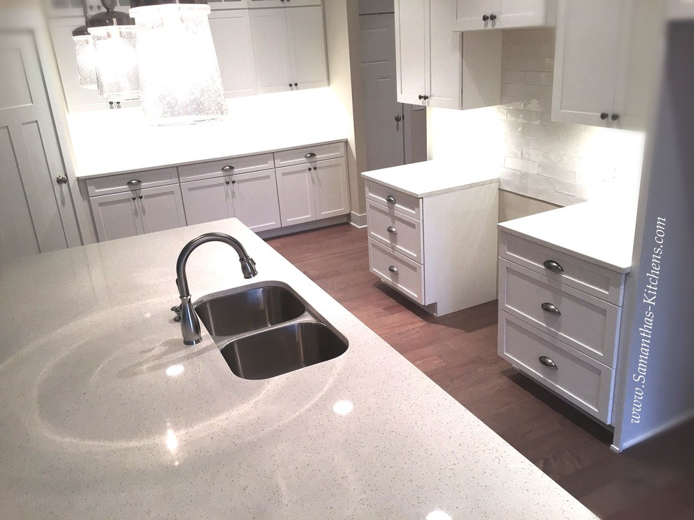 Mid-sized transitional l-shaped medium tone wood floor eat-in kitchen photo with an undermount sink, shaker cabinets, white cabinets, quartz countertops, white backsplash, subway tile backsplash and an island