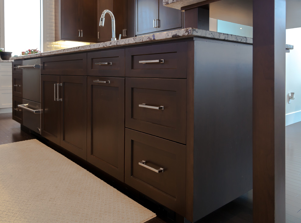 Inspiration for a large transitional u-shaped dark wood floor and brown floor kitchen remodel in Calgary with an undermount sink, shaker cabinets, white cabinets, granite countertops, white backsplash, subway tile backsplash, stainless steel appliances and an island