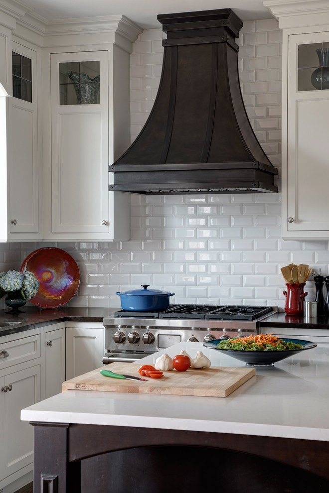 Inspiration for a mid-sized transitional u-shaped medium tone wood floor eat-in kitchen remodel in Chicago with an undermount sink, beaded inset cabinets, white cabinets, granite countertops, white backsplash, subway tile backsplash, stainless steel appliances and an island