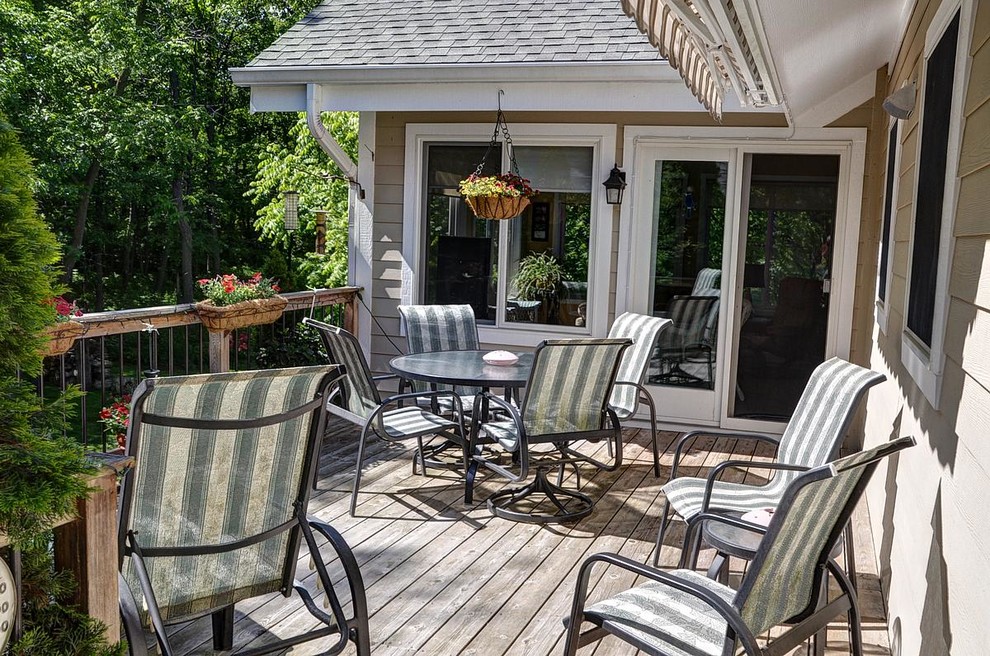 Deck - mid-sized rustic backyard deck idea in Milwaukee with an awning