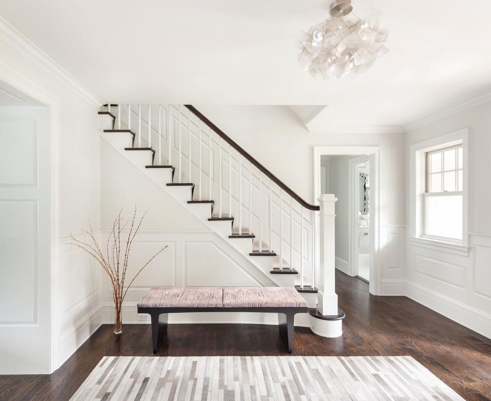 Photo of a transitional foyer in Boston with white walls, dark hardwood floors, a white front door and brown floor.