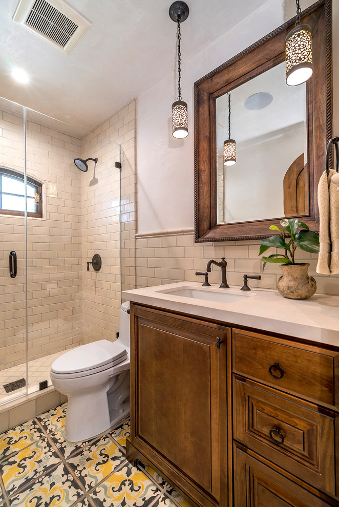 Design ideas for a mediterranean bathroom in San Francisco with an undermount sink, raised-panel cabinets, dark wood cabinets, beige tile, subway tile and white walls.