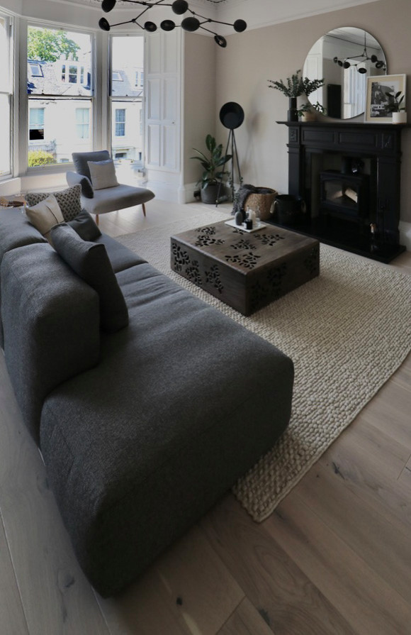 Esempio di un grande soggiorno scandinavo con pareti beige, parquet chiaro, stufa a legna, cornice del camino in legno, porta TV ad angolo e pavimento beige