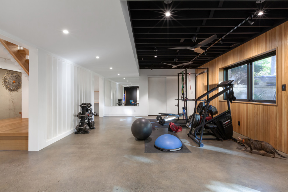 This is an example of a mid-sized scandinavian home weight room in Indianapolis with white walls, concrete floors, grey floor and exposed beam.