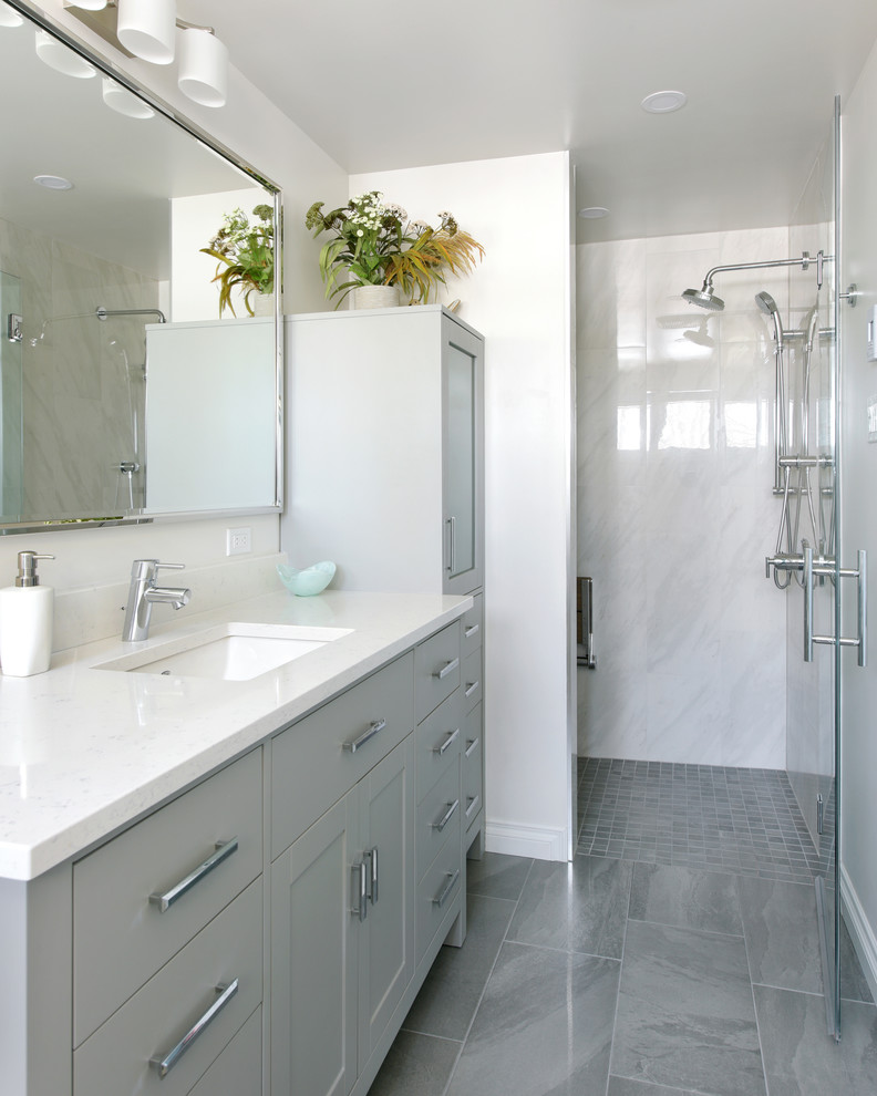 Photo of a large transitional 3/4 bathroom in Ottawa with shaker cabinets, grey cabinets, an alcove shower, a two-piece toilet, white walls, ceramic floors, an undermount sink, engineered quartz benchtops, grey floor, a hinged shower door and white benchtops.